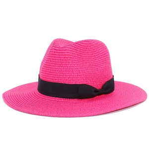 Detail of rose pink straw sun hat featuring black grosgrain ribbon and side bow