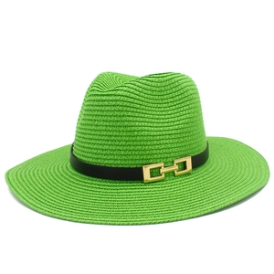 Dettaglio del cappello di paglia verde chiaro con trama intrecciata e fascia nera con fibbia