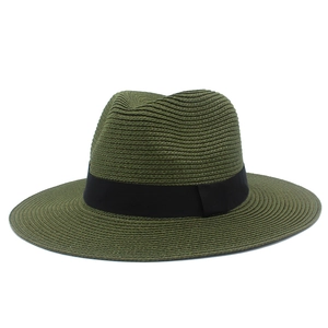 Detail of dark green woven straw hat featuring tight texture and black grosgrain ribbon