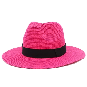Detailed texture of rose pink straw sun hat featuring a classic black decorative ribbon
