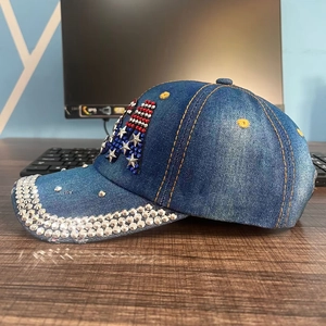 Detail of denim baseball cap featuring US flag rhinestone pattern and crystal brim