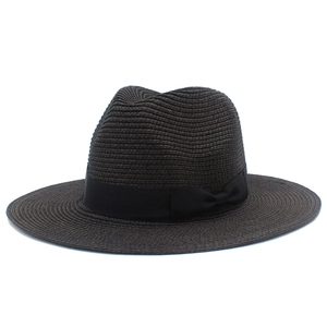 Detailed view of the dark straw sun hat texture and elegant black grosgrain ribbon bow