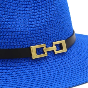 Dettaglio cappello panama blu scuro con cinturino in pelle e fibbia metallica dorata