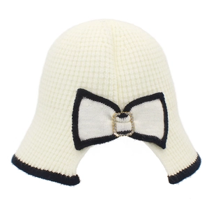 Detail of knitted bucket hat featuring waffle texture and rhinestone bow decoration