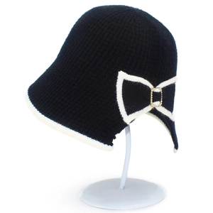 Elegant black knit cloche hat with white trim, bow detail, and rhinestone gold buckle