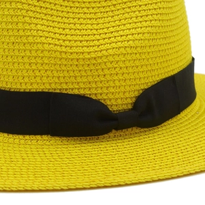 Detail of yellow straw sun hat featuring woven texture and black grosgrain ribbon bow