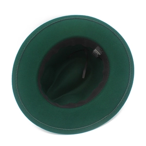 Dettaglio dell'interno del cappello fedora verde con etichetta del materiale e fascia interna