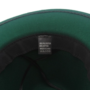 Dettaglio dell'interno di un cappello in feltro verde scuro con etichetta di cura
