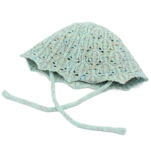 Close-up of knit bonnet hat with openwork diamond pattern and decorative ties