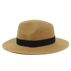 Detail of natural straw weave and minimalist black ribbon bow on a summer sun hat