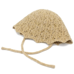 Detailed macro view of beige hollow-out knit bucket hat with delicate wavy edge and straps