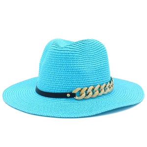 Détail du chapeau de paille turquoise avec ruban en cuir noir et chaîne en métal doré