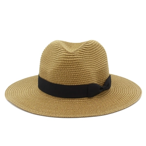 Close-up of woven straw fedora hat with black grosgrain ribbon and side bow detail