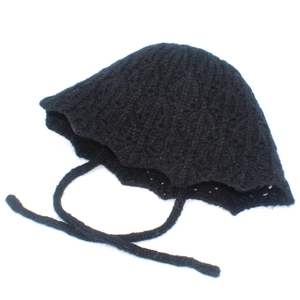 Detailed close-up of a black knit bucket hat featuring delicate hollow texture and chin straps