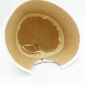 Detail view of knitted bucket hat interior with adjustable strap and ponytail opening