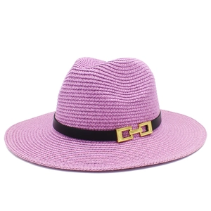 Dettaglio cappello di paglia viola con fascia in pelle nera e fibbia dorata rettangolare