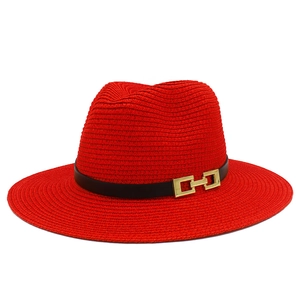 Dettaglio del cappello di paglia rosso con trama fine e fascia nera con fibbia dorata