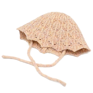Close-up of soft knitted baby bonnet with intricate hollow weave and chin straps