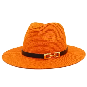 Dettaglio cappello di paglia arancione con fascia in pelle nera e fibbia dorata