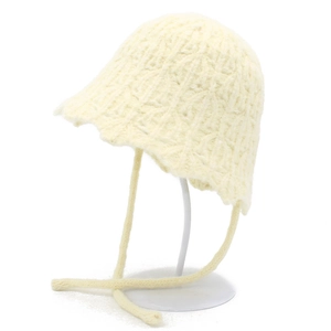 Close-up of cream knit bucket hat with textured crochet pattern and wavy brim details