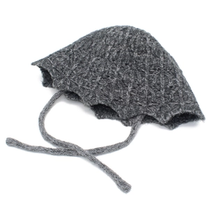 Detailed close-up of dark grey chunky knit wool texture and lace-up ribbon on winter hat
