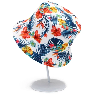 Détail d'un chapeau de soleil à motif tropical avec fleurs d'hibiscus et feuilles de palmier