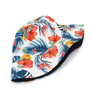 Gros plan du motif de feuilles de palmier et d'hibiscus sur ce chapeau bob blanc