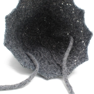 Detailed knit texture of dark grey bucket hat with delicate woven tie straps