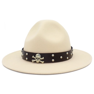 Détail d'un chapeau en feutre crème avec ruban en cuir clouté et emblème de tête de mort