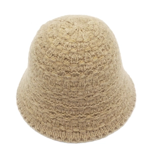 Close-up of beige knitted bucket hat showing thick yarn texture and warm fuzzy finish