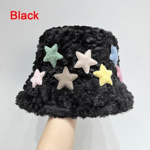 Dettaglio del cappello alla pescatora in pelliccia sintetica nera con stelle colorate e peluche