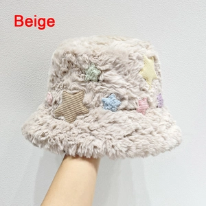 Dettaglio della trama del cappello a secchiello beige con decorazioni a stelle colorate