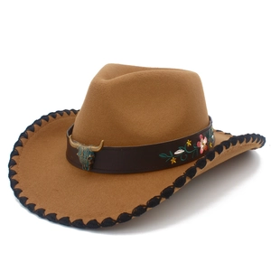 Close-up of cattle head metal buckle and floral embroidery on western cowboy hat