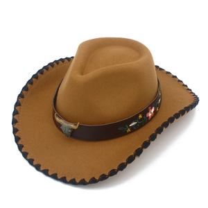 Detail of a brown western cowboy hat with bull head ornament and floral embroidery.