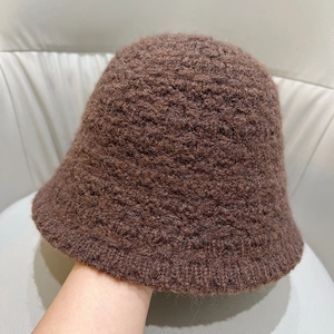 Close-up of deep brown thick knit bucket hat showing warm wool-like texture and weave
