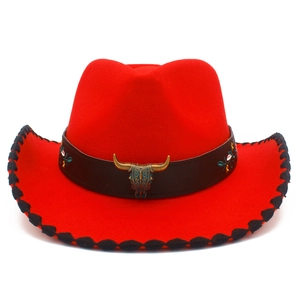 Detail of red cowboy hat featuring leather band and carved metal bull skull pendant