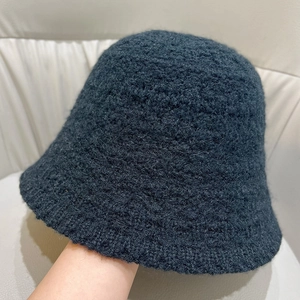 Detailed texture of a black knitted bucket hat with thick warm plush wool fabric