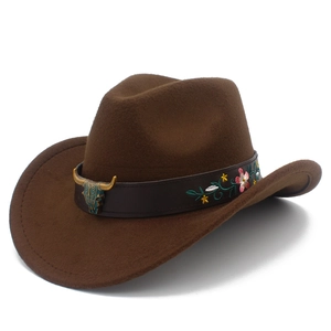 Detail of dark brown cowboy hat featuring bull head ornament and colorful floral embroidery