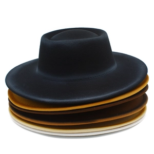 Detail shot of multi-colored wool felt boater hats stacked in a stylish gradient display