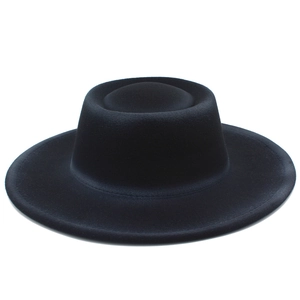 Detail of minimalist black wool fedora with structured flat brim and indented crown