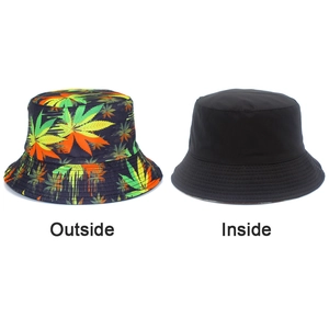Detail view of reversible bucket hat showing colorful leaf print and black solid interior