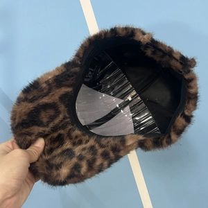 Detail of plush leopard print baseball cap showing faux fur texture and black fabric lining