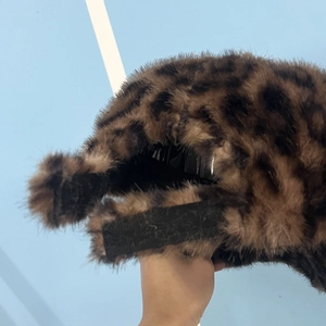 Detail of plush leopard print baseball cap featuring soft faux fur and velcro strap closure