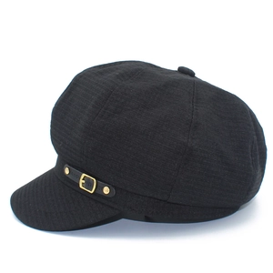 Detail view of black octagonal newsboy cap with leather strap and gold buckle accent