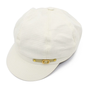 Detail of off-white newsboy hat with textured fabric and golden metal buckle decoration