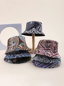 Detailed view of various paisley bucket hats displayed on elegant wooden stands