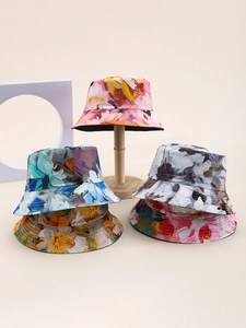 Detailed view of floral tie-dye bucket hats in pink, blue and grey canvas colors