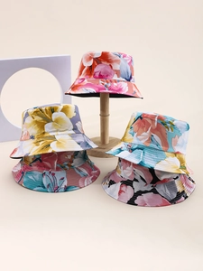 Close-up of floral pattern bucket hats in multiple colors on a wooden stand
