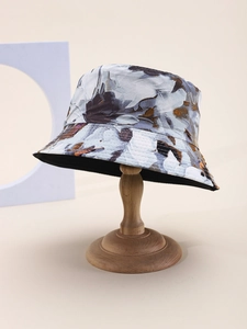 Detailed view of tie-dye bucket hat with abstract floral pattern on a wooden stand