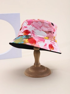 Detail view of pink tie-dye bucket hat with floral print on a wooden display stand